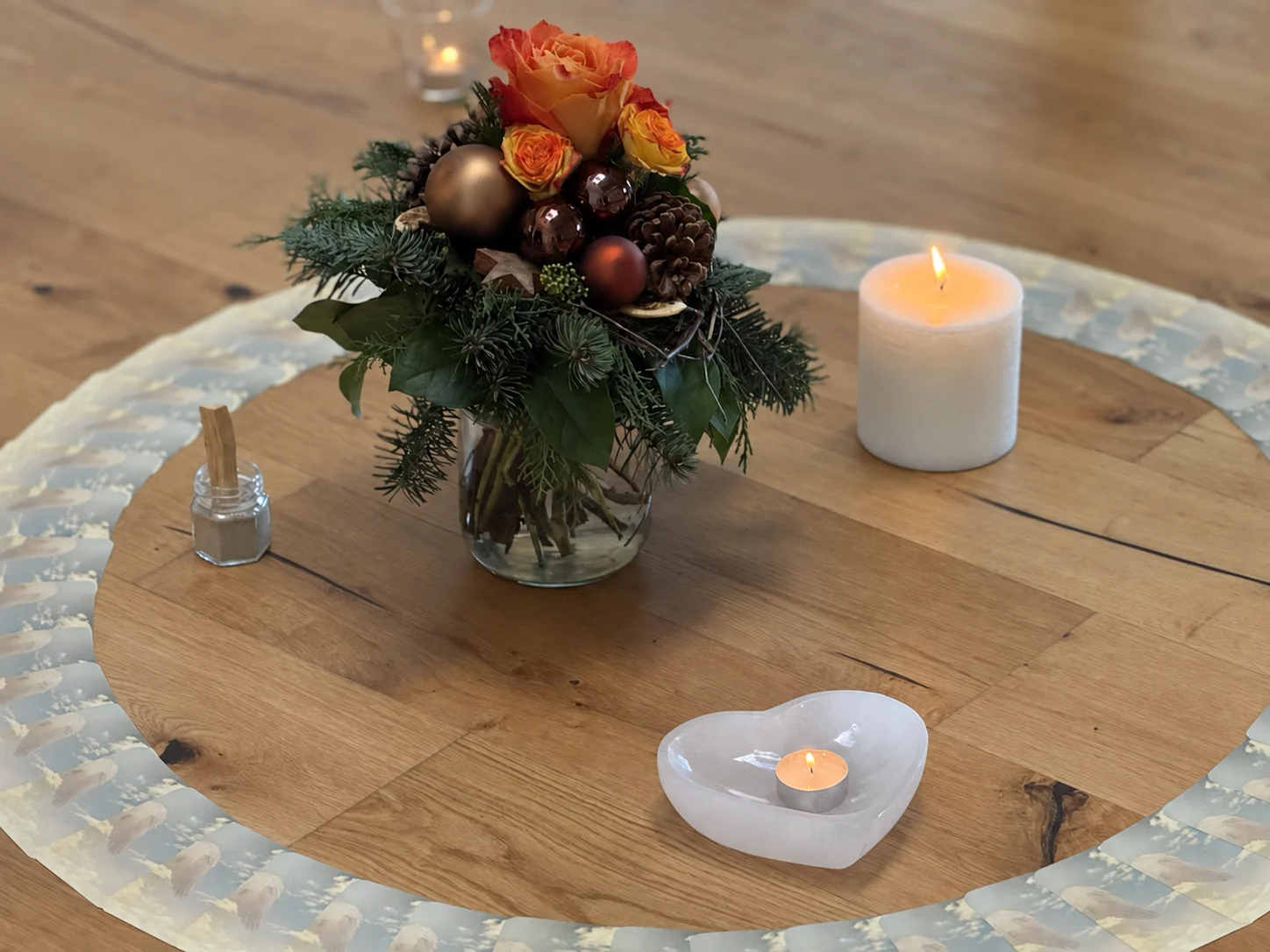 Herbstliches Tischgesteck mit Kerzen und Kakaozutaten auf einem runden Holztisch