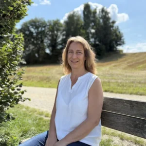 Andrea Daniel Coaching: Andrea auf einer Bank in der Natur